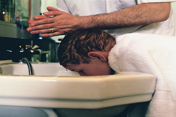 摄图网_501473035_给男孩洗头发的理发师（企业商用）.jpg
