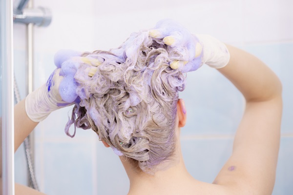 摄图网_300887967_女人头发上涂上着色洗发水紫色洗涤产品的女家里涂金色女人头发上涂墨粉洗发水（企业商用）.jpg